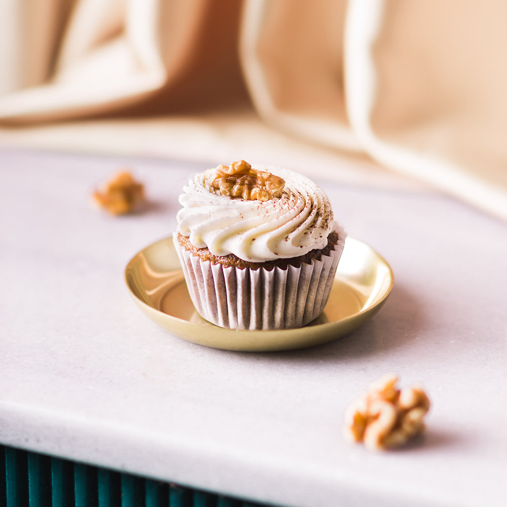 Indulge in a delicious and moist carrot cupcake, with its warm and spicy flavors and a dollop of creamy frosting. Pair it perfectly with a crisp and refreshing Brut Cava, with its subtle fruit notes that complement the cupcake&