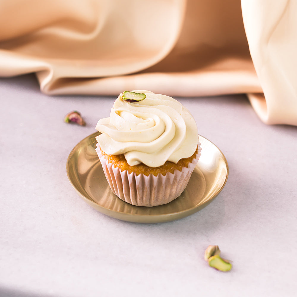 Cupcake de vainilla con frosting de pistacho y topping de pistacho